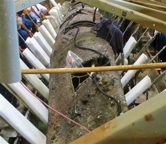 The Confederate submarine H.L. Hunley rests on its side as workers adjust slings to move it upright on Wednesday at a conservation lab in North Charleston, S.C. When the process is completed, the hand-cranked sub will be upright for the first time since it sank with its crew of eight in 1864.